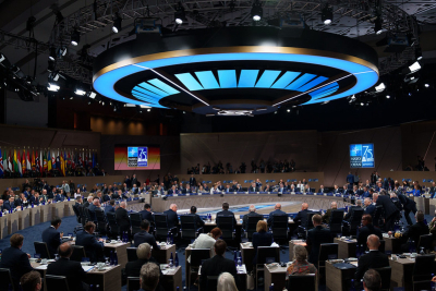 Skats uz sanāksmju zāli, kurā dalībniei sēž pie saviem galdiem